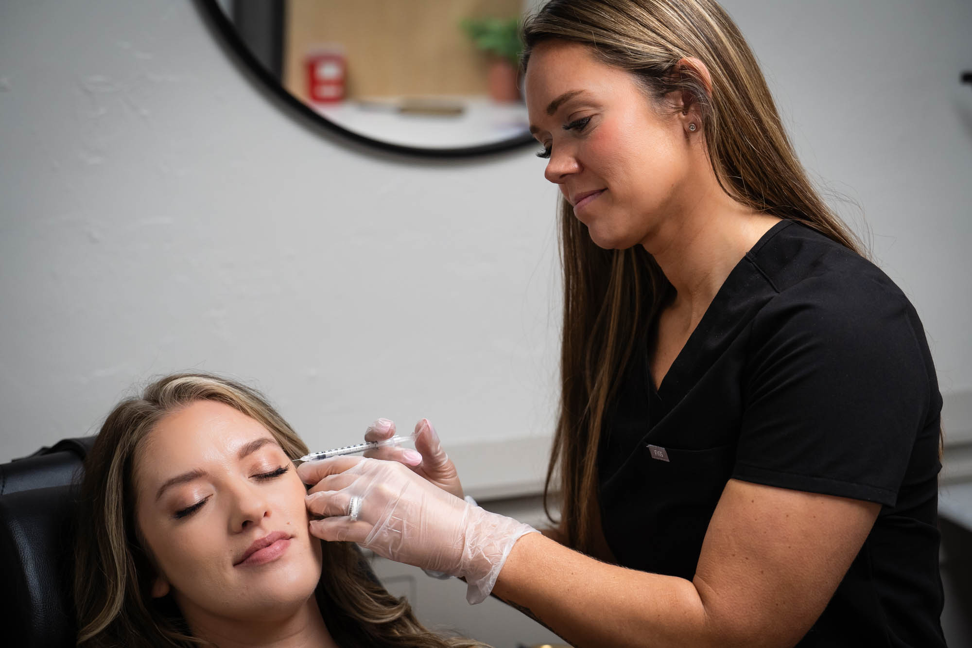 An injector administers a patient's temporalis and masseter muscle Botox in Winchester, Indiana.