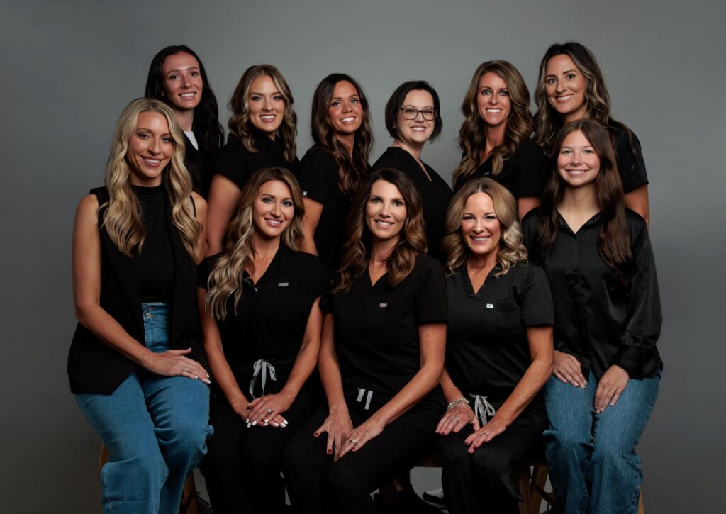 Our expert staff at Evolve Medical Aesthetics + Wellness sits together for a photo, ready to help you with laser hair reduction in Muncie, Indiana, when you book your appointment.