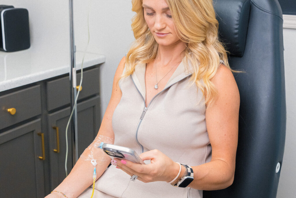 Alt text: A patient reclines in a comfortable treatment room as she receives an IV infusion, much like B12 shots, in Muncie, Indiana.